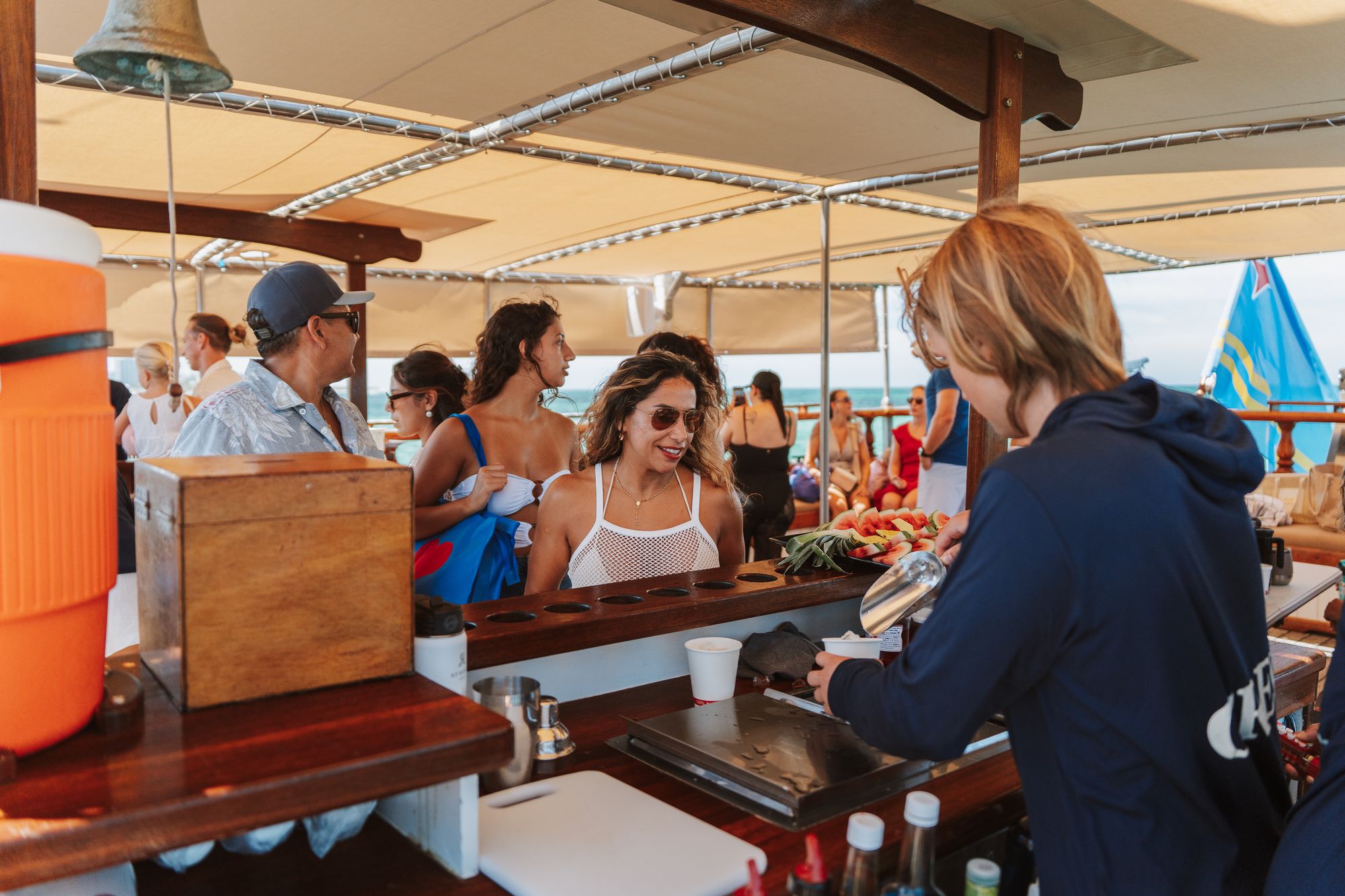 Guests ordering drinks at the open bar under the shade on the Flagship
