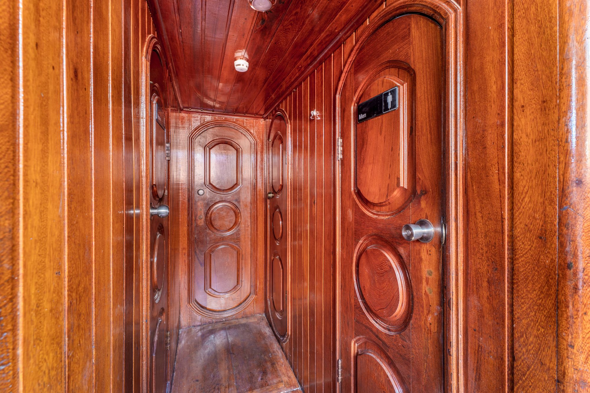 Polished wooden hallway leading to the bathrooms on board the Flagship